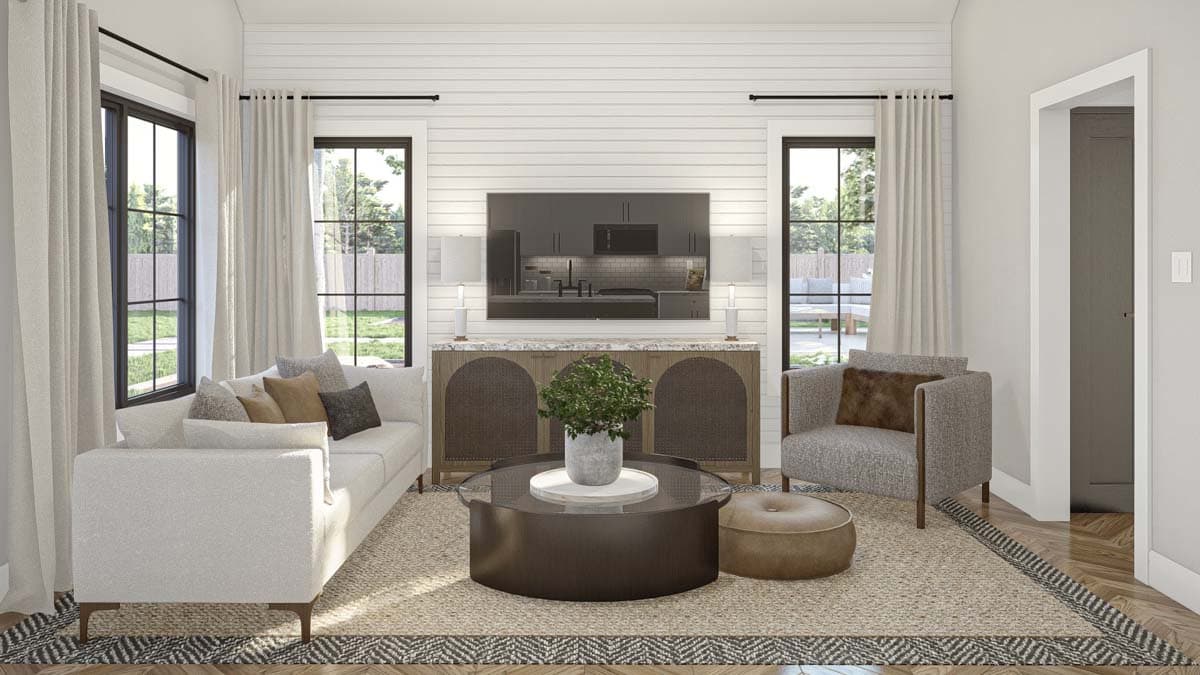 Living room with white shiplap walls, sofa, armchair, round coffee table, and large windows.