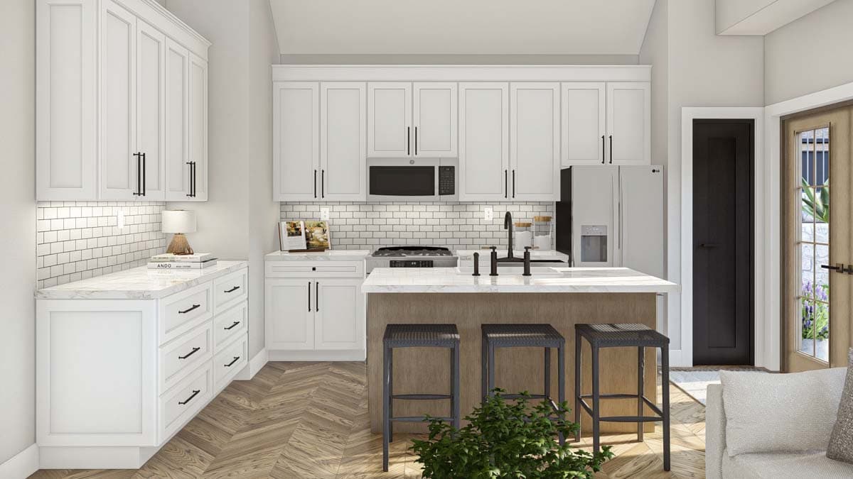 Kitchen interior with white shaker cabinets, subway tile backsplash, island with seating, and stainless steel appliances.