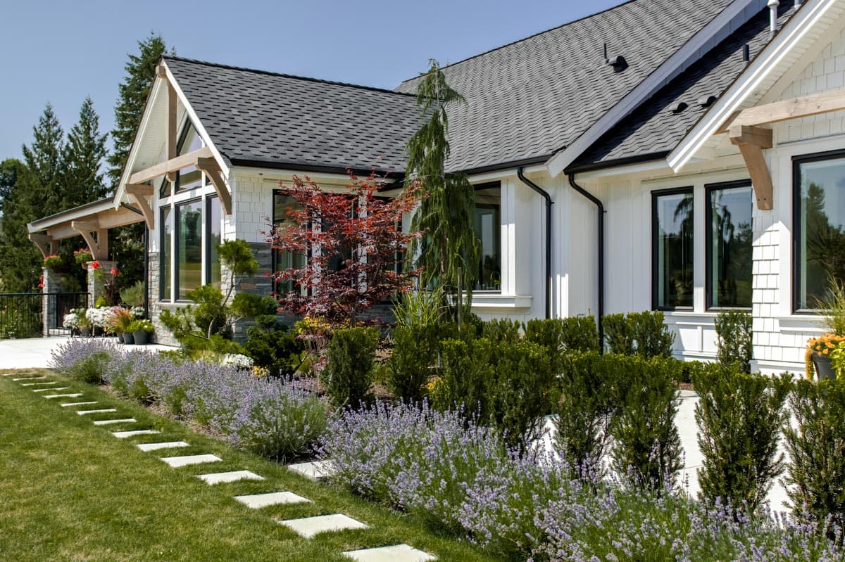 House plan exterior featuring a covered porch, gables with exposed beams, and stacked stone accents.