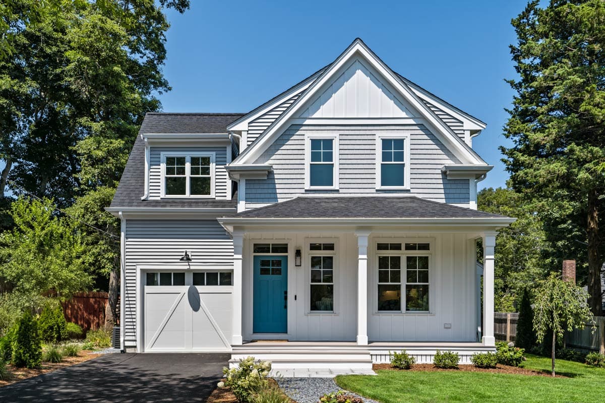 House plan exterior: Two-story Modern Farmhouse with shingle siding, prominent gables, covered porch, and attached garage.