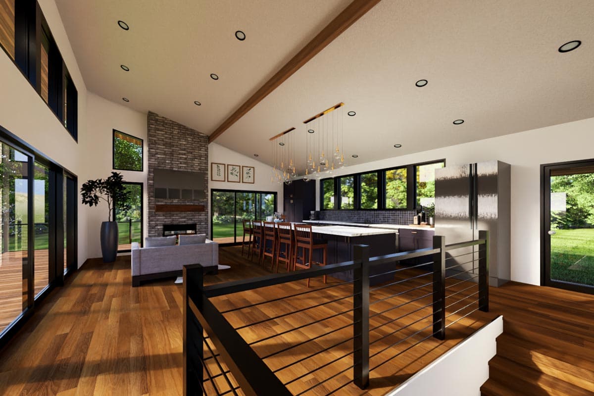 Vaulted ceiling open concept great room with stone fireplace, large kitchen island, and ample windows.