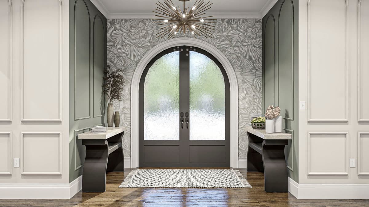 Entryway with arched double doors, fluted molding, patterned wallpaper, and console tables.