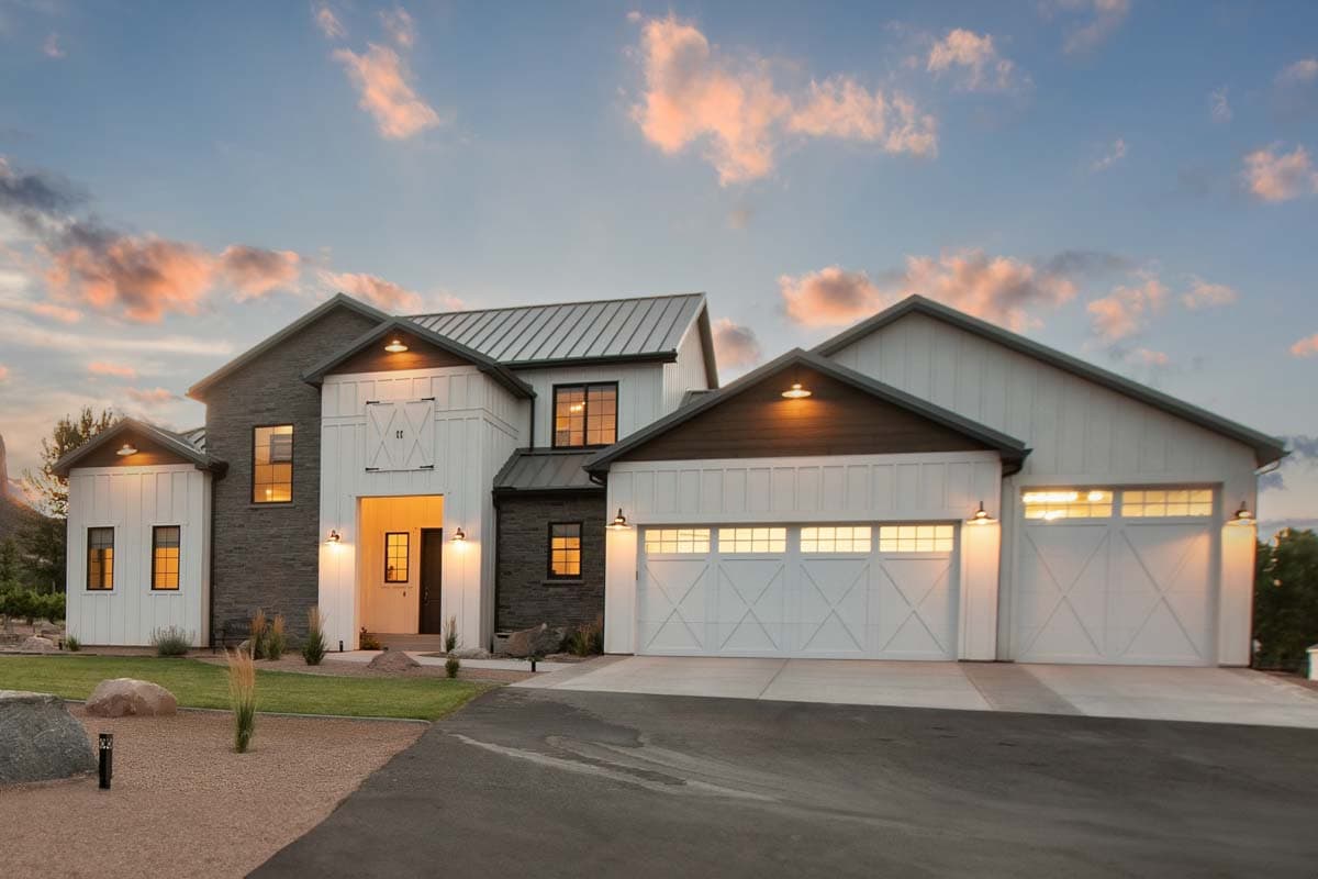 Modern Farmhouse house plan exterior with metal roof, stone and board and batten siding, and a three-car garage.
