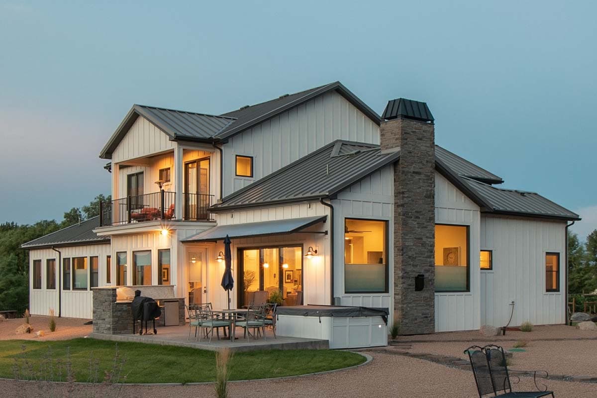 Modern Farmhouse house plan exterior with two stories, gables, balcony, and stone chimney.