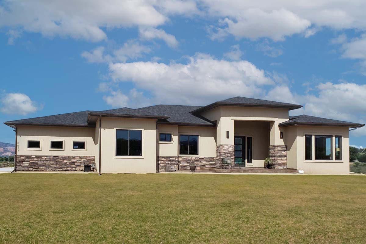 Modern house plan exterior with stone accents, flat roof, entryway porch, and large windows.