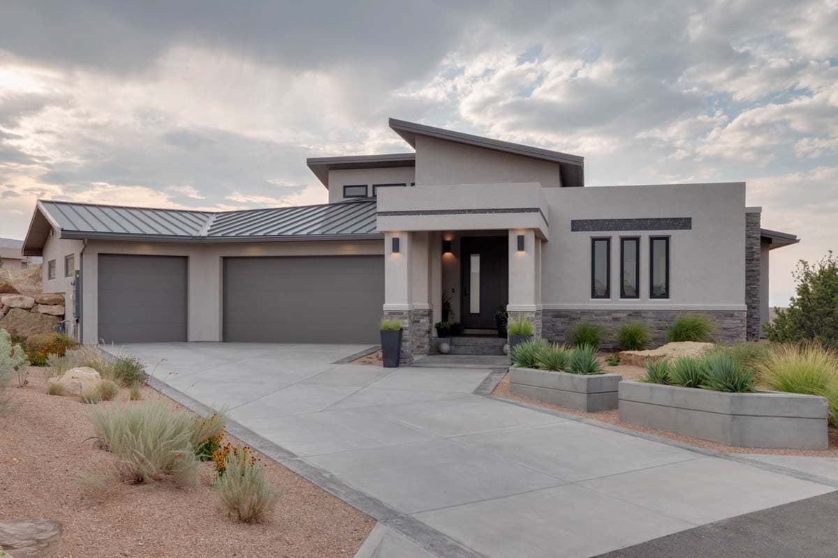 Modern house plan exterior with a three-car garage, flat rooflines, stucco finish, and stone accents.