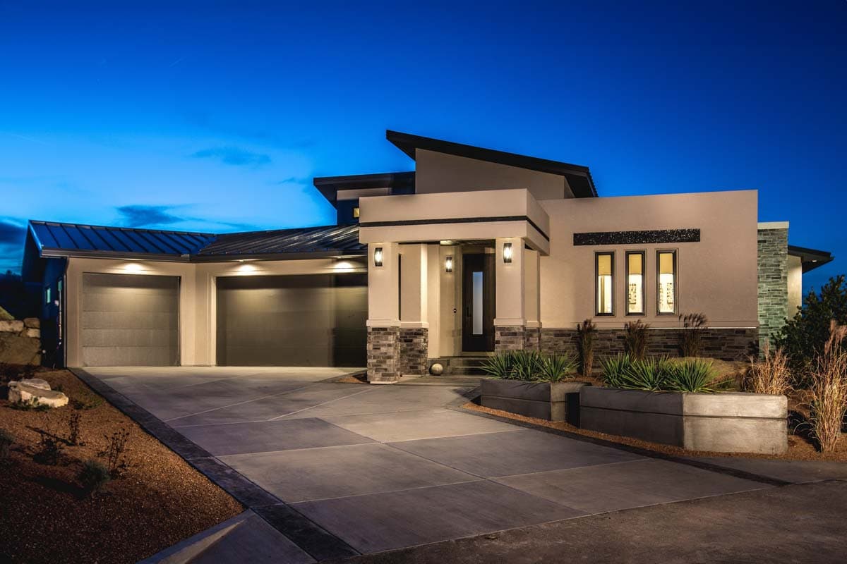 Modern house plan exterior with a three-car garage, angled rooflines, stacked stone accents, and a covered entryway.