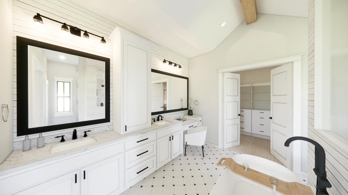 Bathroom with double vanity, freestanding tub, and double doors leading to a walk-in closet.
