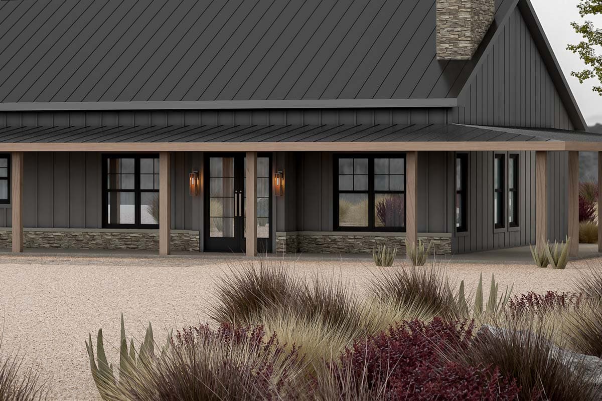 Modern Farmhouse exterior with metal roof, covered porch with wood supports, stone base, and black-framed windows.