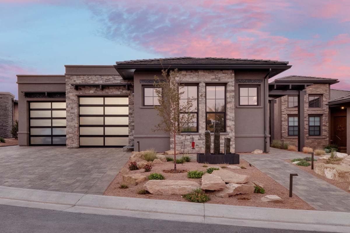 House plan exterior with stone veneer, flat roof, and two-car garage. Features include large windows and a contemporary design.