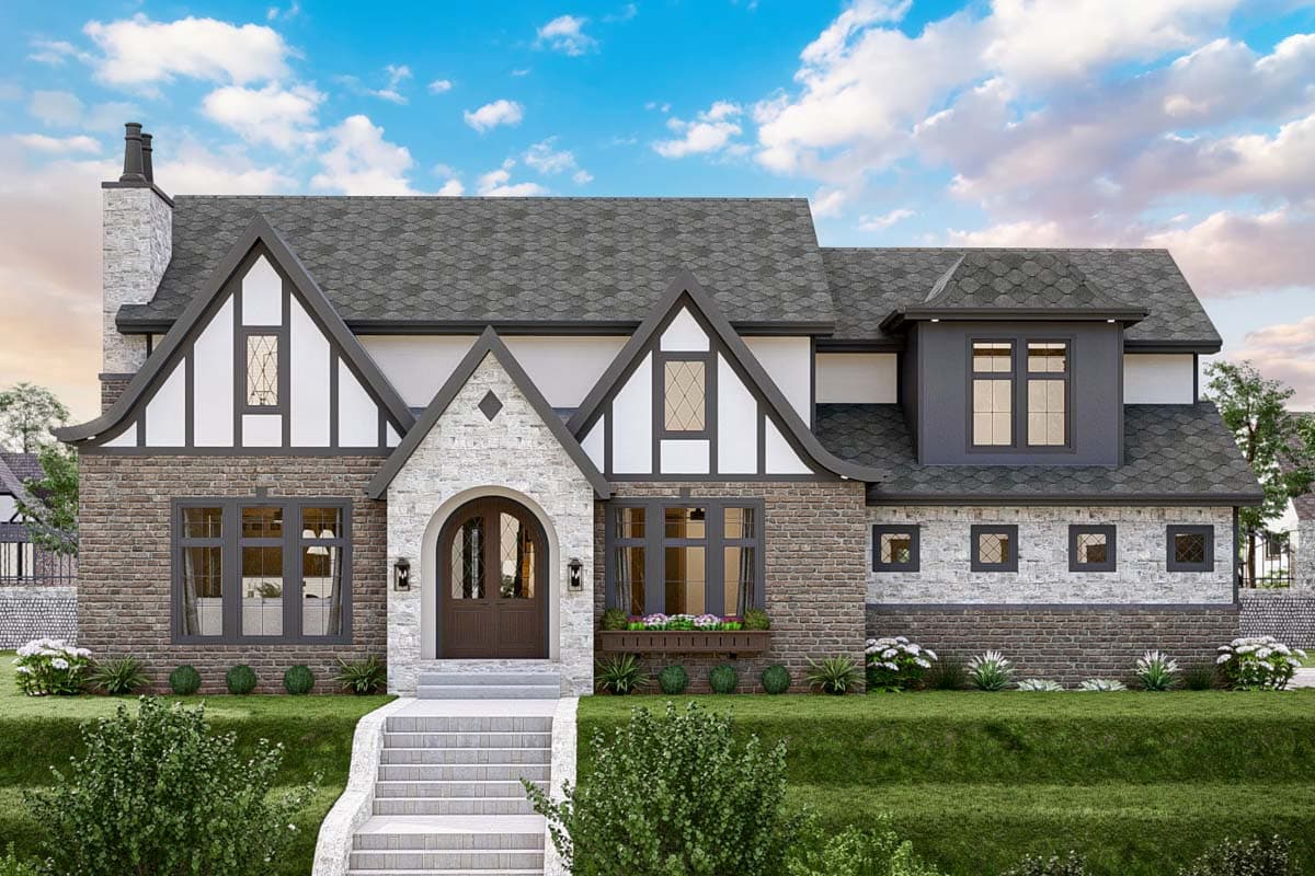 House plan exterior. Tudor style, two-story home with gabled roof, stone facade, arched entryway, and multiple gables.