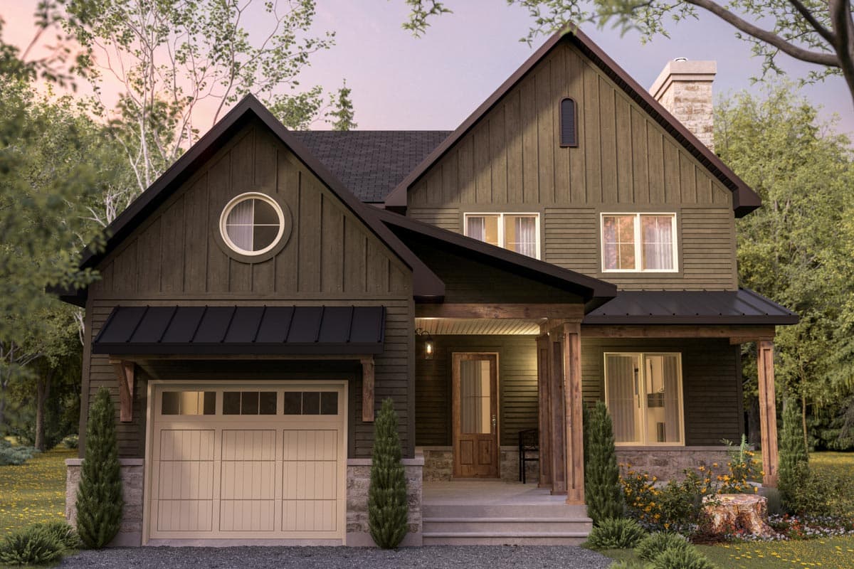 Exterior view of a modern two-story house. Features a dark green exterior, black accents, and a beige garage door. Surrounded by trees.