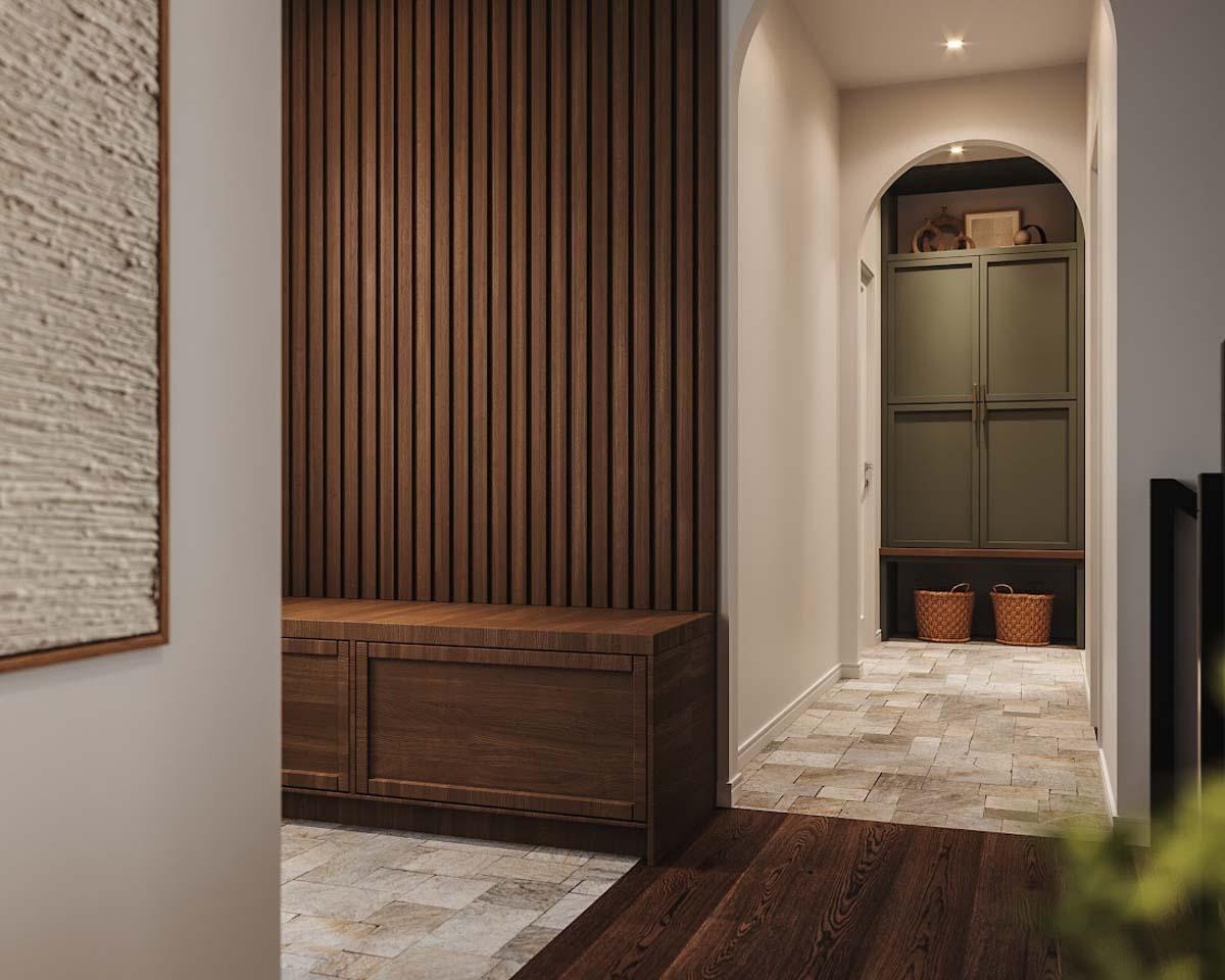 Hallway with wood paneling, bench, and arched entrance leading to storage cabinet and stone tile floor.