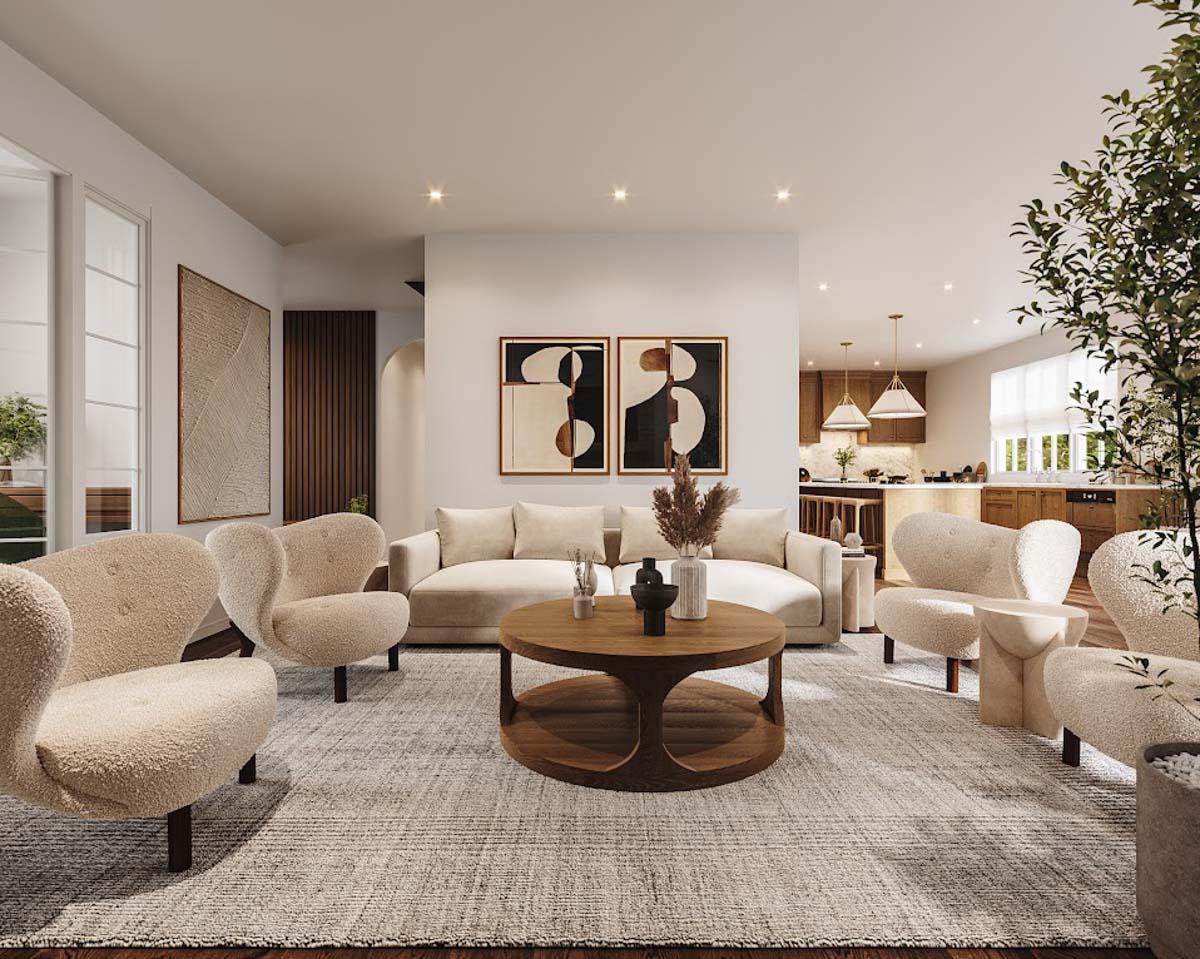 Modern living room with neutral colors, round coffee table, and cozy armchairs. Open to the kitchen in the back.
