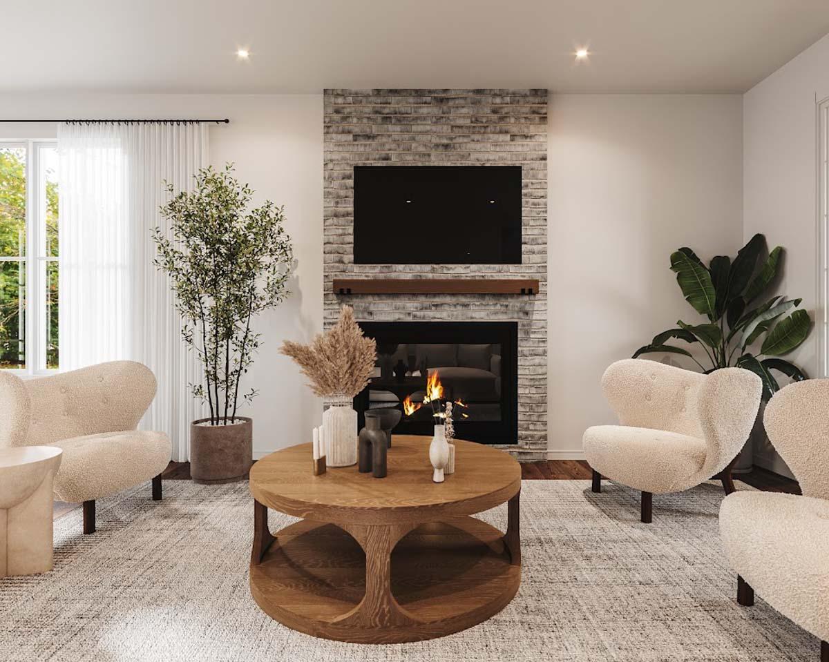 Cozy living room with fireplace, modern chairs, round coffee table, and plants, creating a welcoming and stylish interior.