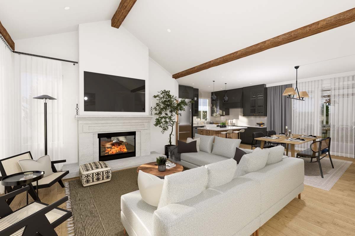 Open concept living area with fireplace, integrated kitchen, and dining space. Vaulted ceilings with wood beams.