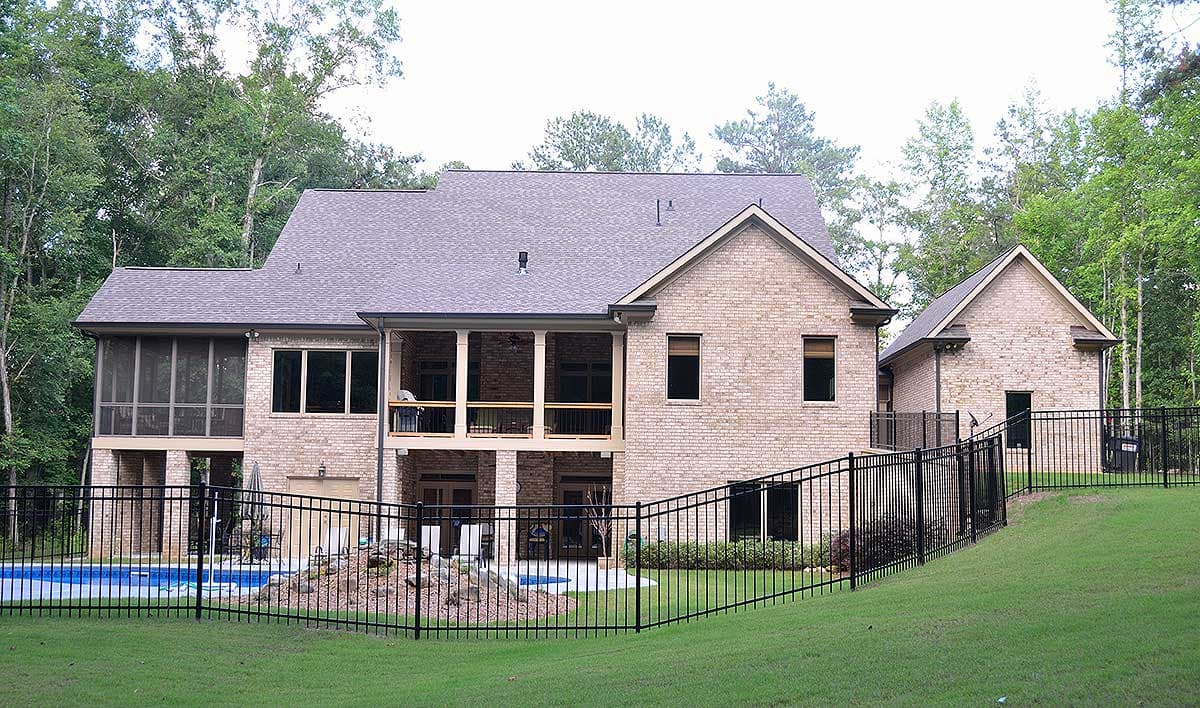 House plan exterior shows a multi-story brick home with a screened porch, upper balcony, and attached garage.