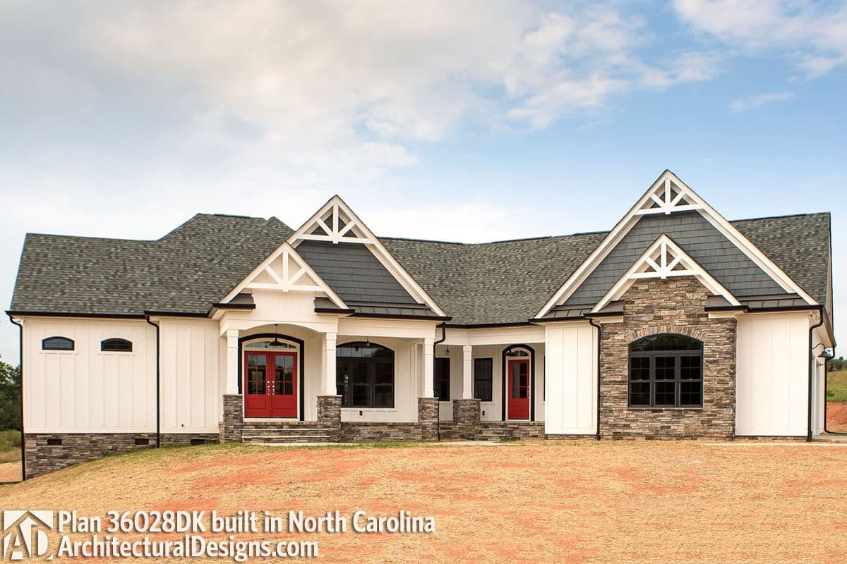 House plan exterior: One-story Modern Farmhouse with double red front doors, stone accents, gables, and covered porches.