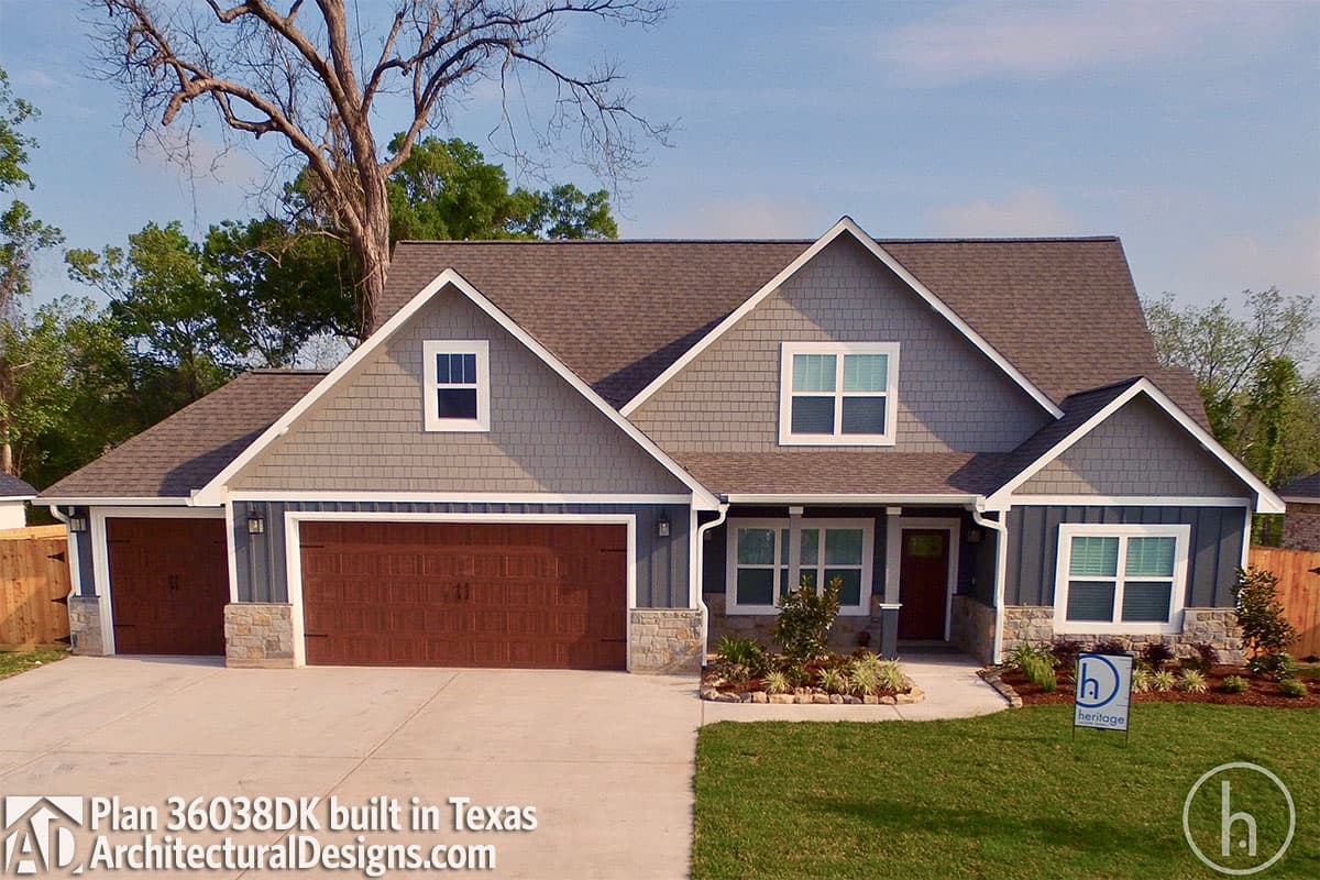 House plan exterior with gables, dormers, stone accents, and a three-car garage with wood-look doors.