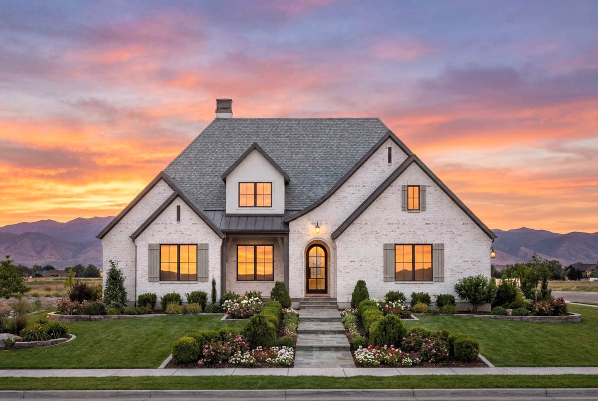 House plan exterior: Modern Farmhouse style, two stories, white brick, prominent gables, dormer, and arched entry.