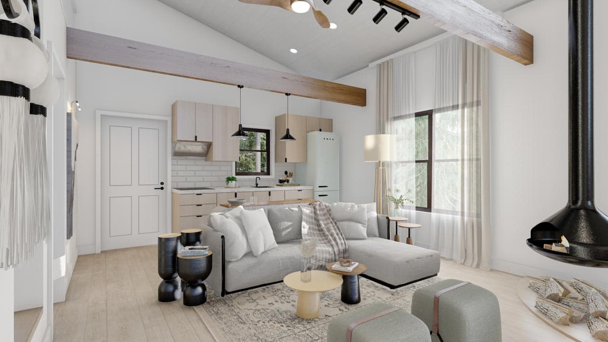 Open concept living area with vaulted ceiling, exposed beams, kitchen, and fireplace.