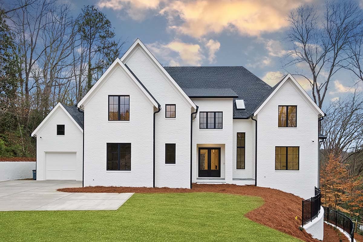 House plan exterior with two stories and a Modern Farmhouse style. Features include multiple gables, black-framed windows, and a detached garage.