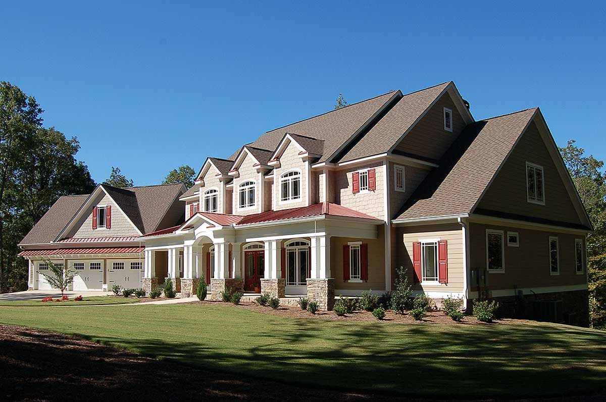 House plan exterior: two-story home with a large wraparound porch, multiple gables, dormers, and a three-car side-entry garage.