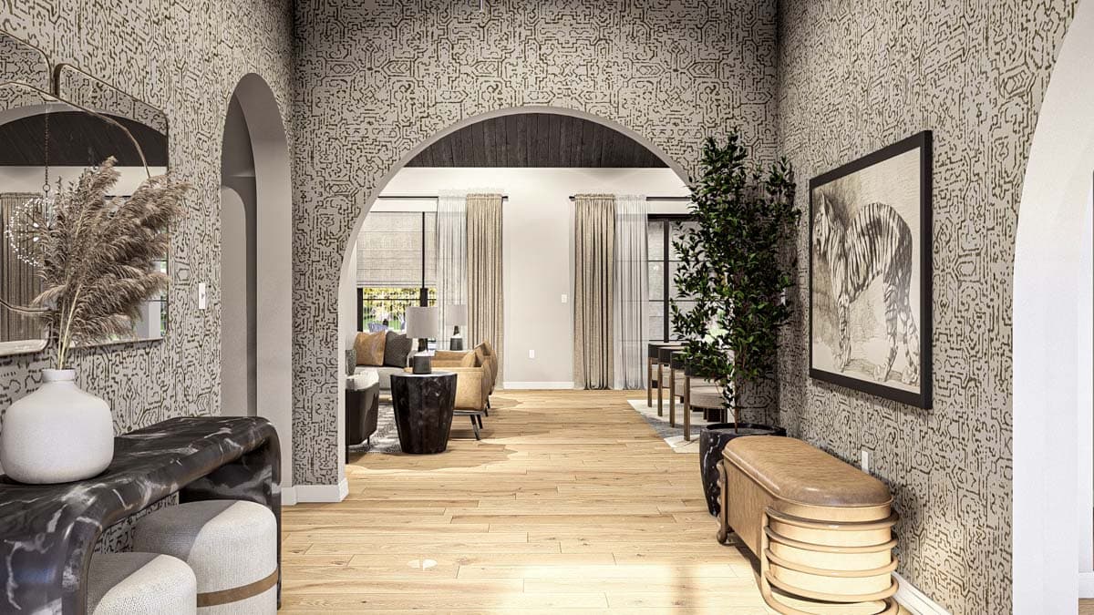 Interior view of a hallway with arched doorways opening to a living area, featuring patterned wallpaper, wood floors, and decorative furniture.