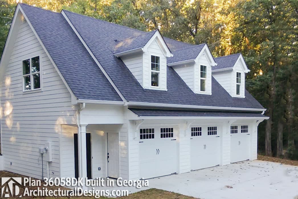 Modern Farmhouse house plan exterior with three garage bays, white siding, dark roof, and three dormers.