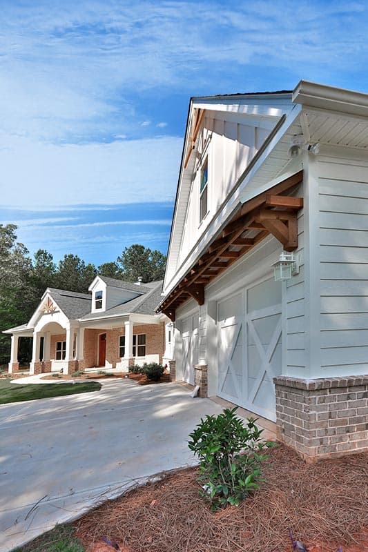 Modern Farmhouse house plan exterior with a two-car garage, gable, and covered porch with brick accents.