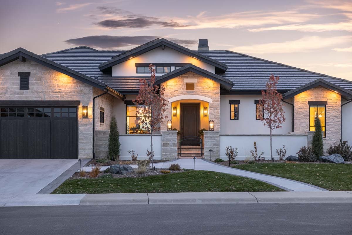 House plan exterior of a one-story Modern Ranch home with stone accents, a dark garage door, arched entryway, and multiple gables.