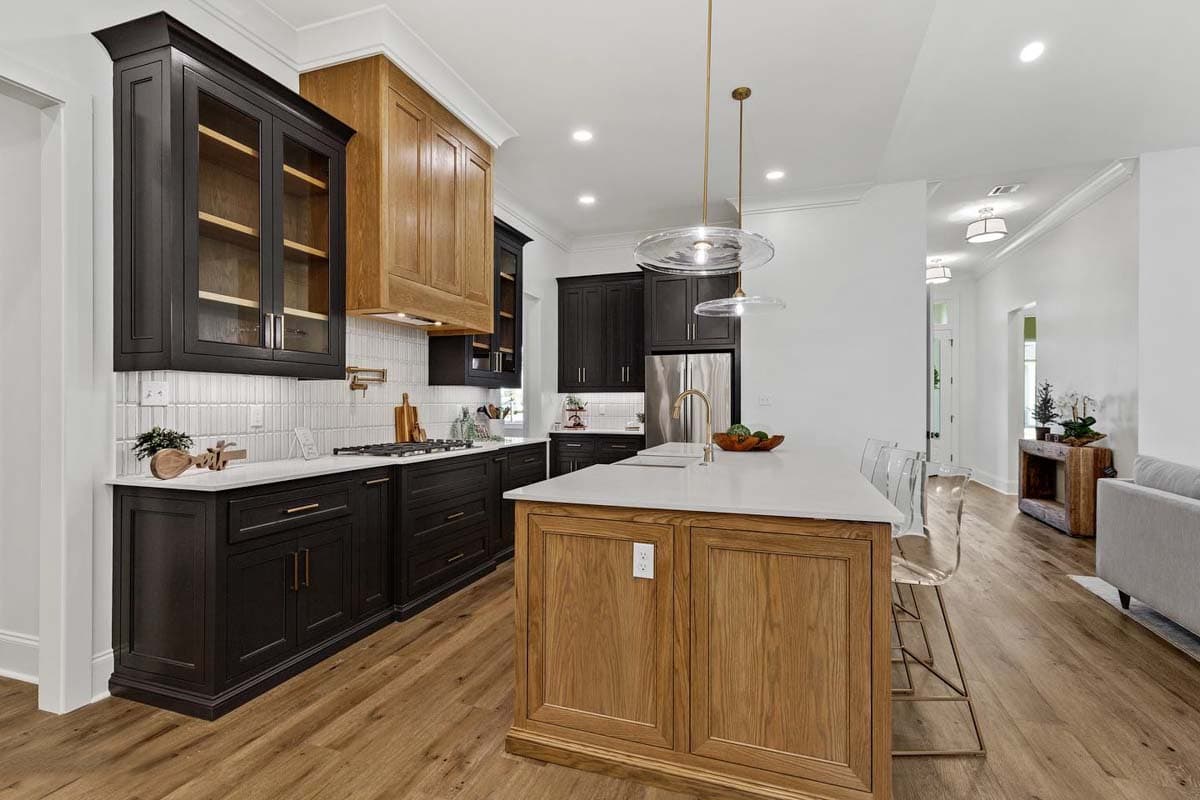 Kitchen with dark cabinets, wood island, white countertops, stainless steel appliances, and pendant lighting.