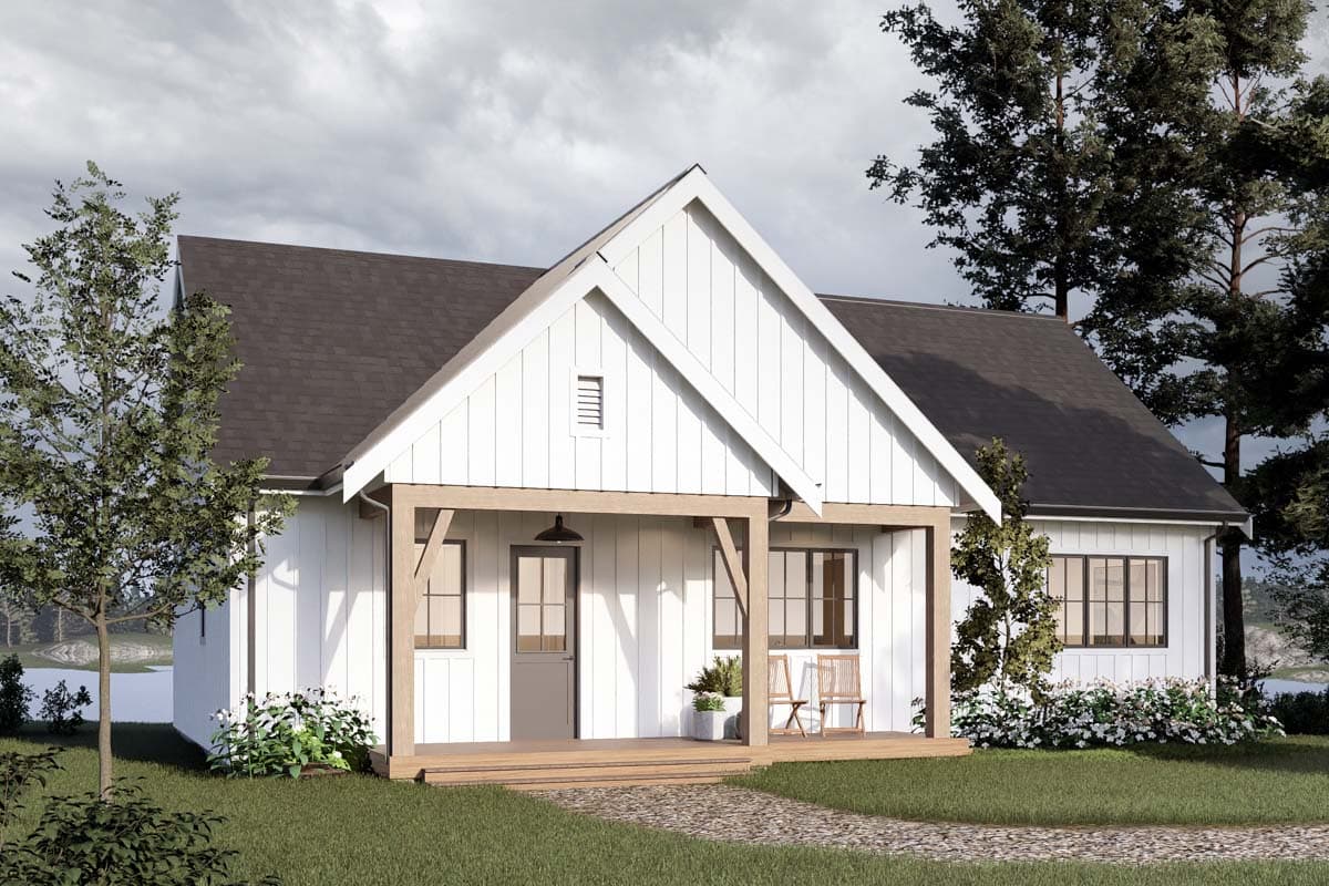 A white, modern farmhouse with a porch and wooden accents. It sits on a grassy lawn with a stone path leading to the entrance, surrounded by trees.