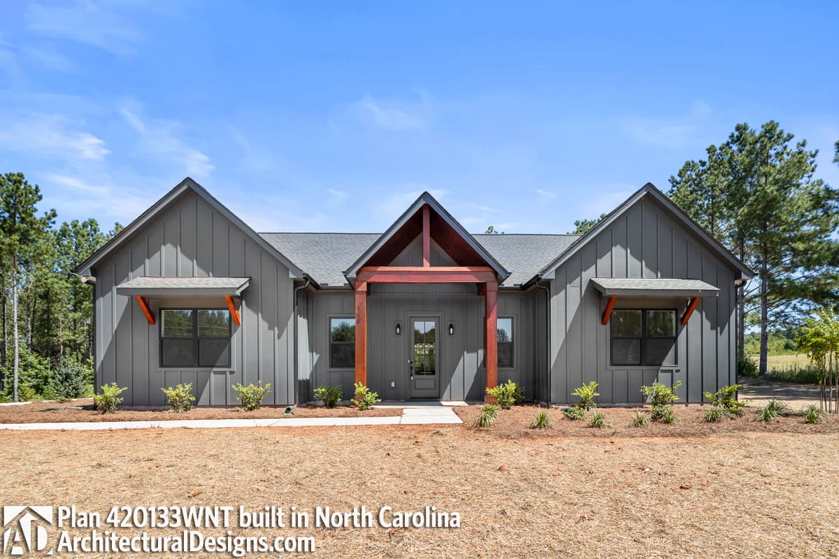 Modern Farmhouse house plan exterior with board and batten siding, prominent gables, and a covered entry with timber accents.