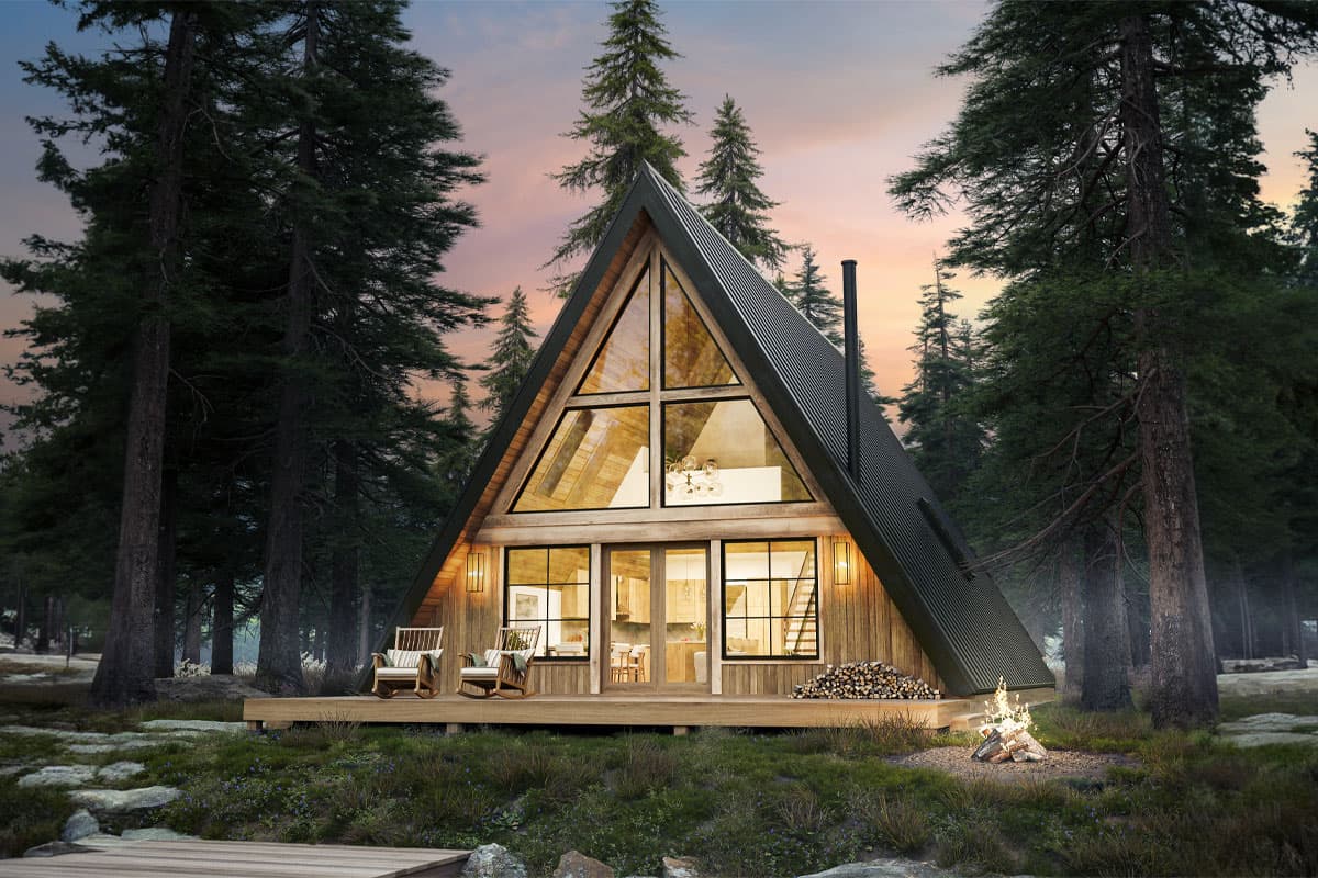 House plan exterior, A-frame style. Features a large window wall, a deck with seating, and a corrugated metal roof. Set in a wooded area.