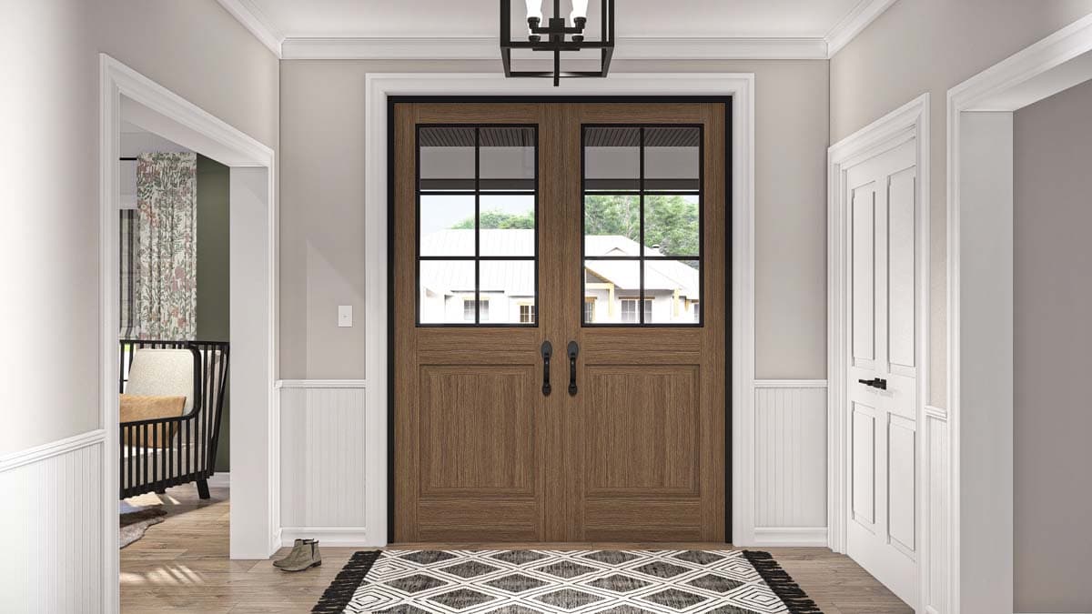 Interior view of a home with double wood doors featuring glass panes, wainscoting, and a geometric rug.