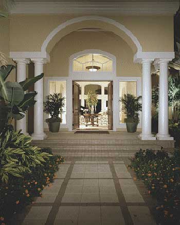 House plan exterior featuring an arched portico with columns, double entry doors, and flanking sidelight windows.