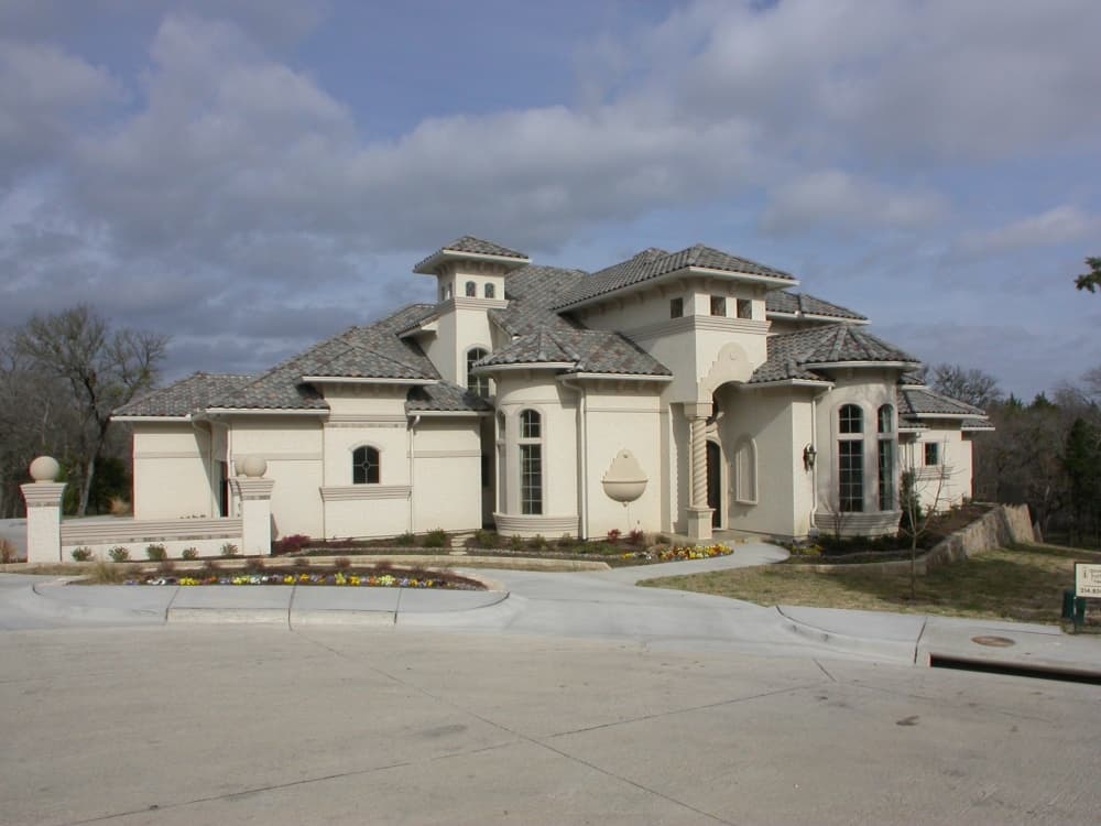 House plan exterior: Multi-story Mediterranean-style home with arched entry, tower, and clay tile roof.