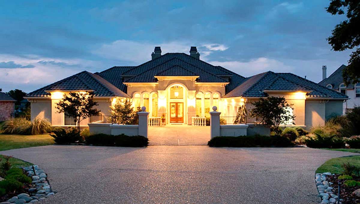 House plan exterior of a one-story Mediterranean-style home with a prominent arched entryway, dual chimneys, and a tiled hip roof.