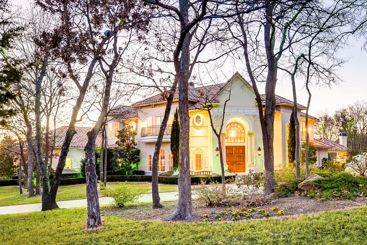 Two-story Mediterranean style house plan exterior with tiled roof, arched entryway, balcony, and multiple gables.