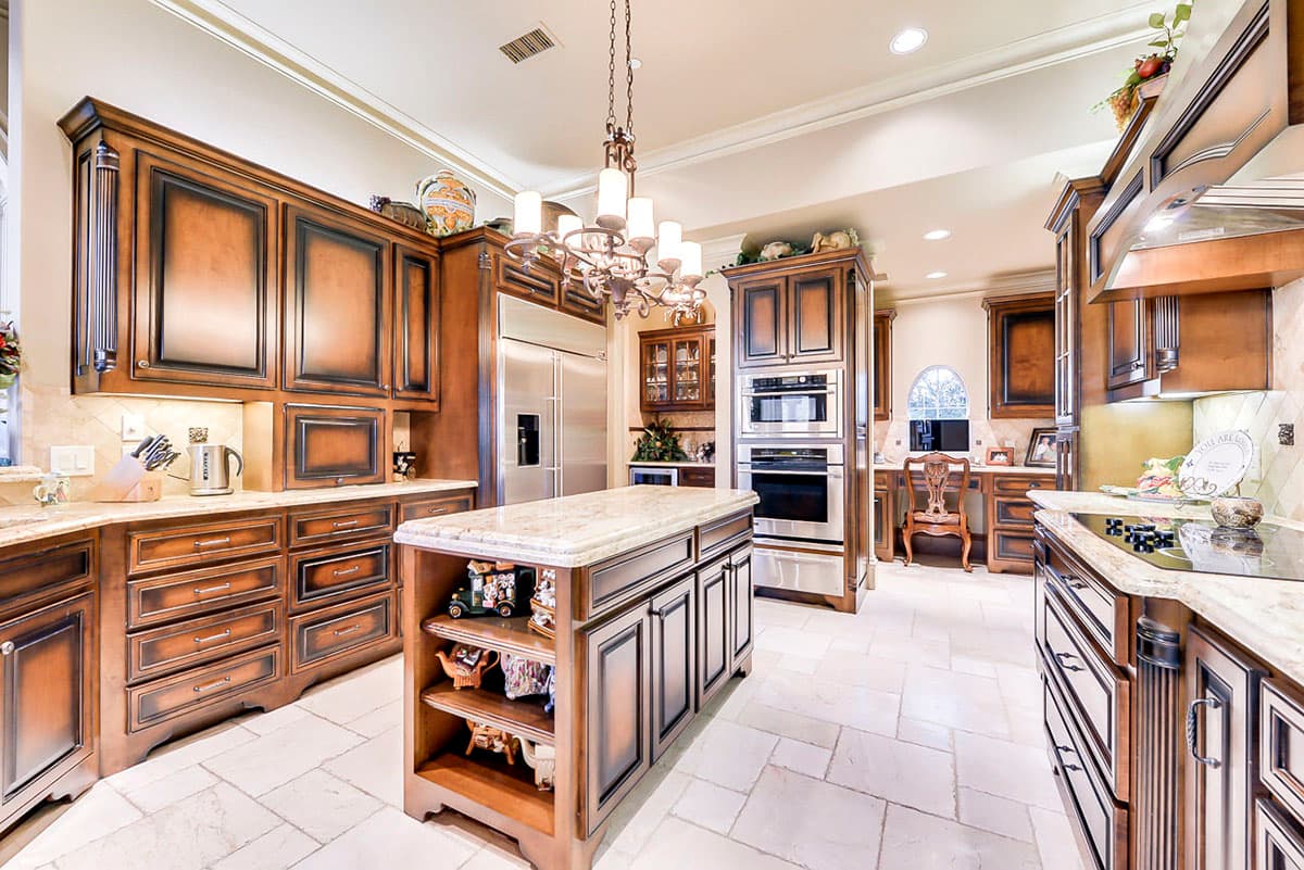Kitchen interior with wood cabinetry, granite countertops, stainless steel appliances, and center island.