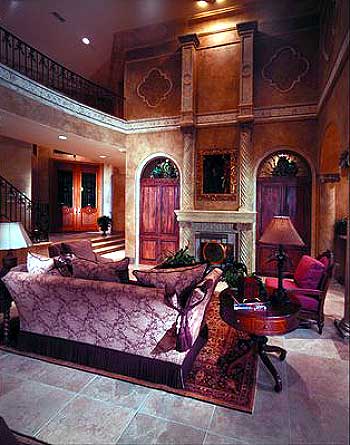 Interior rendering of a grand living room with a fireplace, ornate columns, double doors, and a balcony overlooking the space.