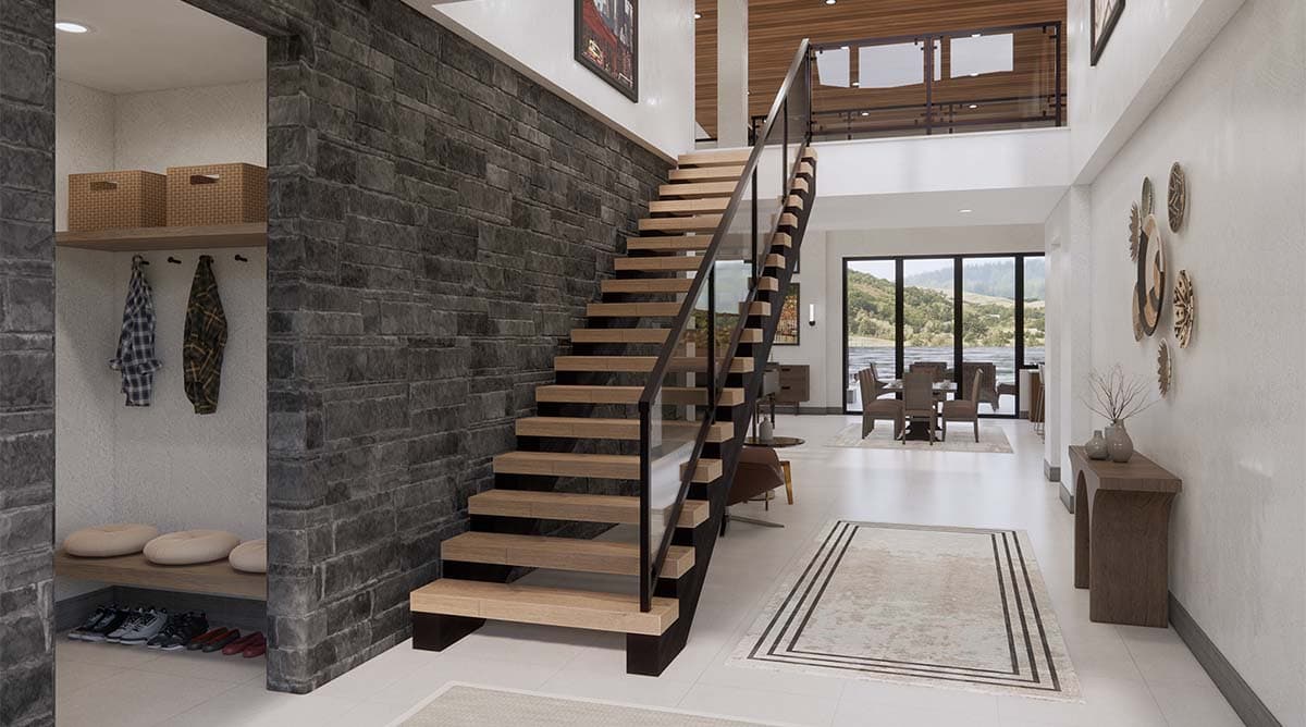Interior view of house showing floating wood staircase with glass railing, stone accent wall, and dining area with large windows.