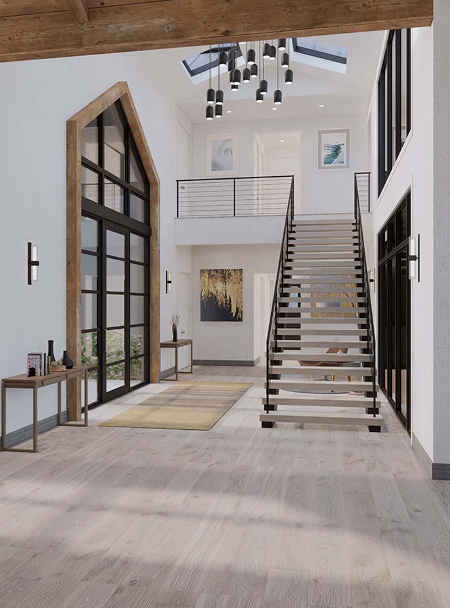 Interior view of a house plan showing an open foyer with a dramatic A-frame window, floating stairs, and a loft balcony.