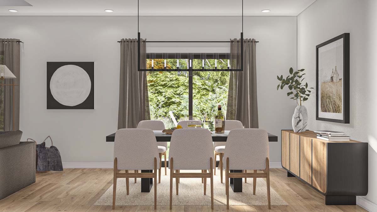 Dining room with table, chairs, buffet, and large window overlooking trees.