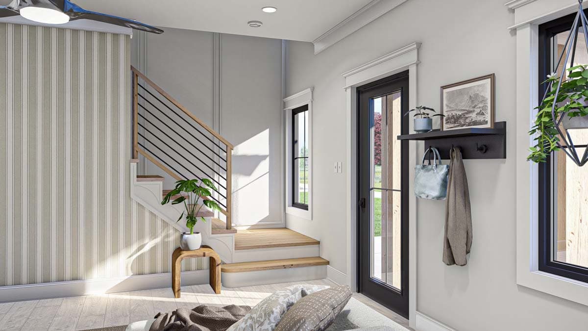Interior view of a house entry with wood-paneled stairs featuring black railings, a striped accent wall, and a glass door.