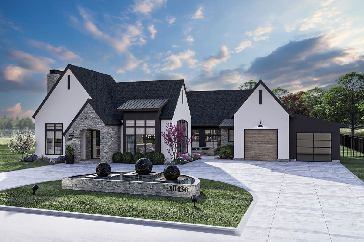 House plan exterior. Modern Farmhouse style with two stories, gabled rooflines, stone facade, and a detached garage.