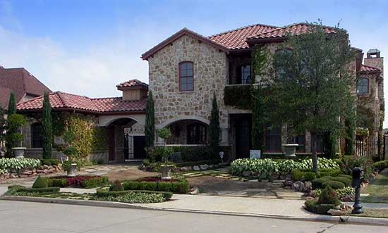 House plan exterior: Stone facade, two stories, red tile roof, arched entryway, and manicured landscaping.