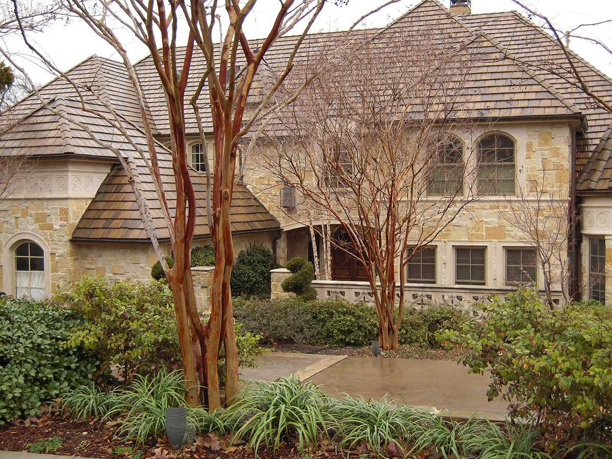 House plan exterior with stone facade, multiple gables, and arched windows.