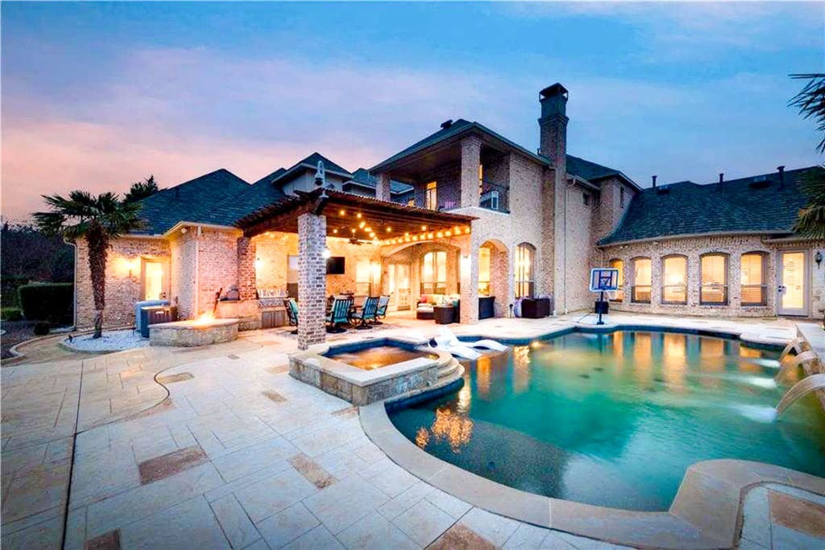 Two-story brick house exterior with covered patio, pool, spa, and fire pit.